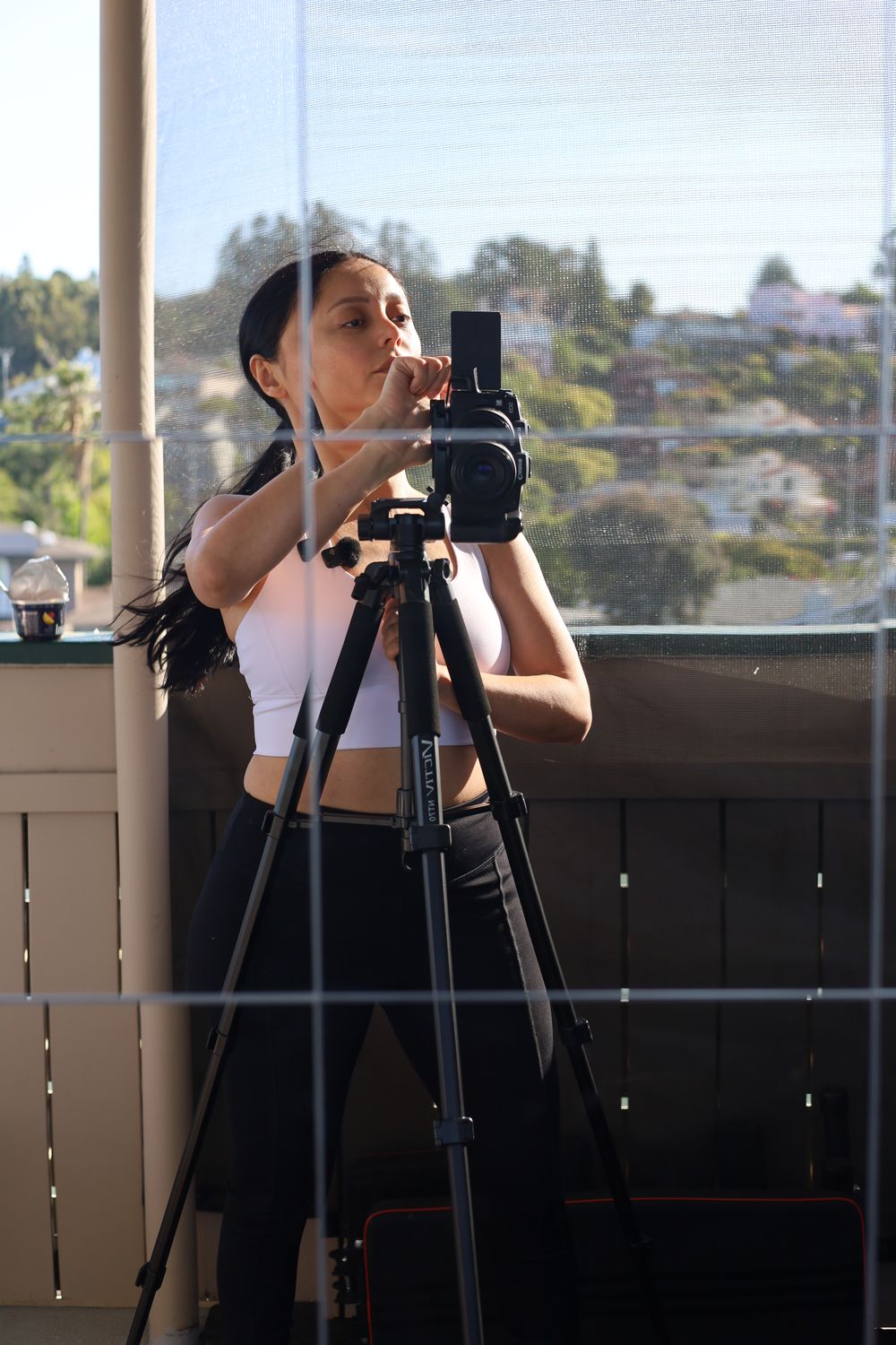 Angie framing a shot through her camera on a tripod